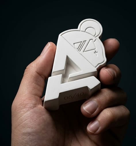 Emblema Actitud Exclusive in gesso, pezzo numerato 06 su 40, tenuto in mano